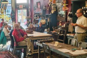 Dr. Alejandro Comellas discusses research translation with rural residents at a cafe.
